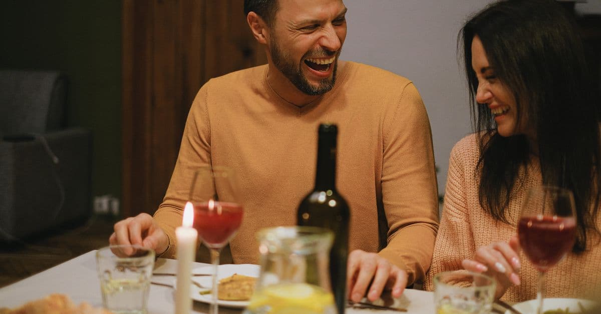 Shared laughter between two people in a comfortable home setting.